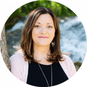Melanie Taylor in front of a waterfall, teaching trauma-informed yoga practices