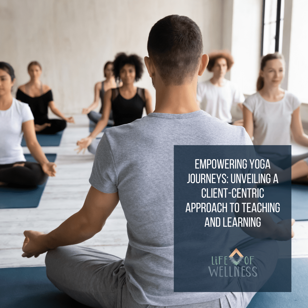 A yoga taecher at the front of the room with yoga students.