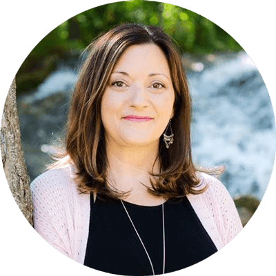 Melanie Taylor – Meet our Teachers Melanie Taylor in front of a waterfall, teaching trauma-informed yoga practices